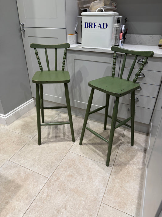 green stool chairs with back infant of grey kitchen with bread bin on counter top 
